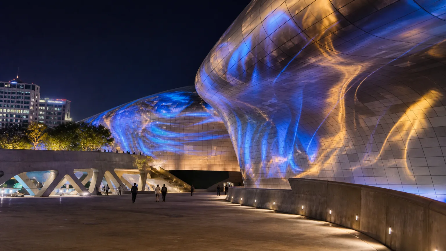 Illustrative nighttime view of the curved exterior of Dongdaemun Design Plaza illuminated with abstract blue and amber light